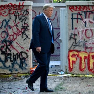 President Donald Trump Walks Past Graffiti Insulting Him