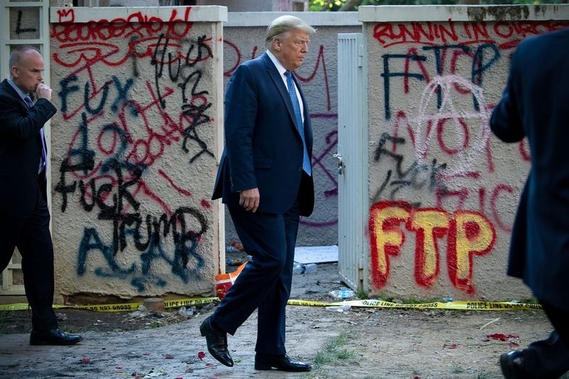 President Donald Trump Walks Past Graffiti Insulting Him